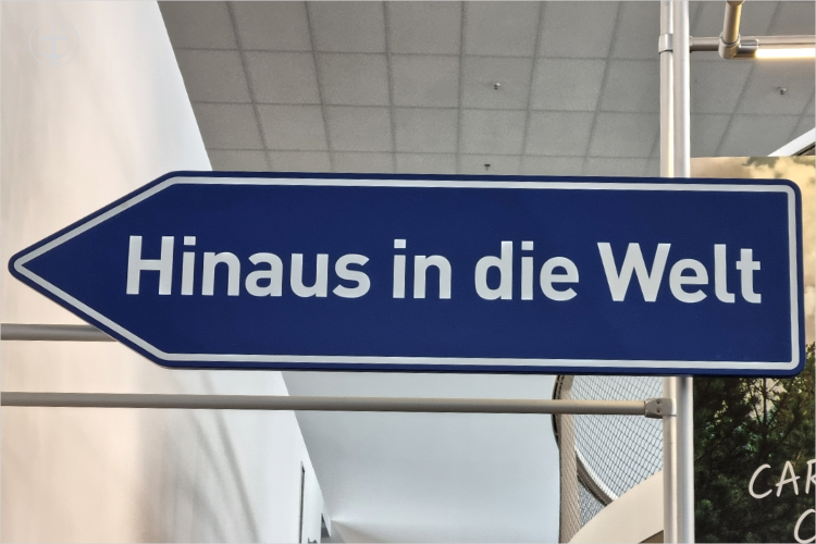 Strassenschild mit der Aufschrift – Hinaus in die Welt von Daniela Joss